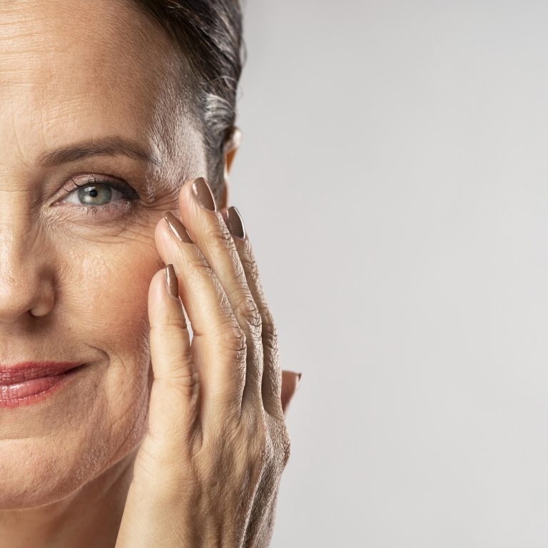 smiley-mature-woman-with-make-up-posing-with-hand-face